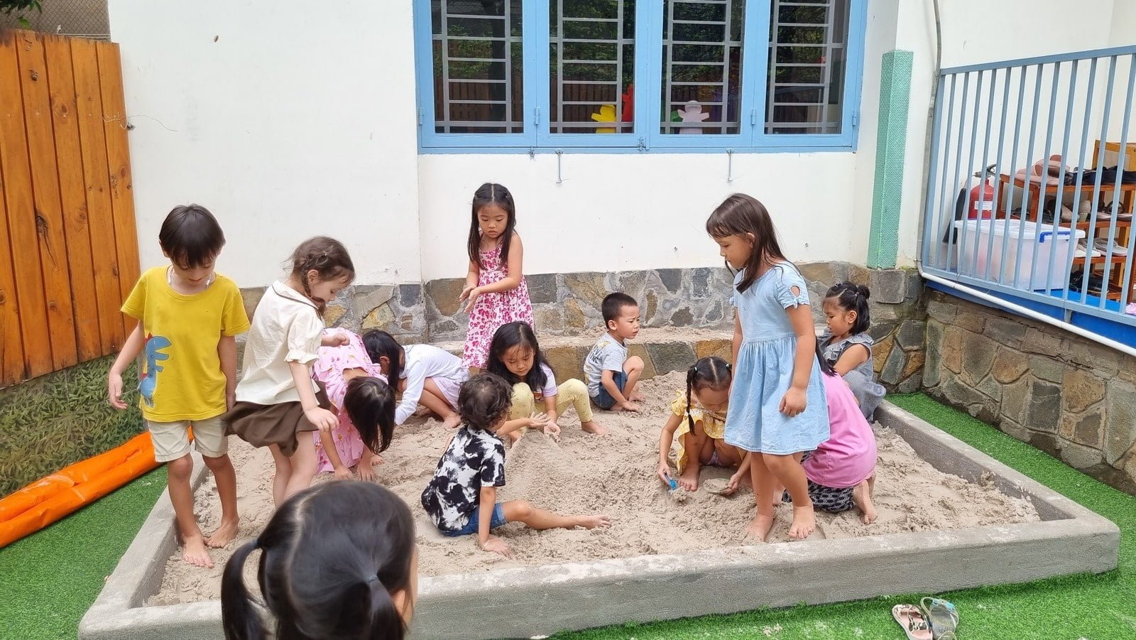 Các bé chơi trong hố cát của trường