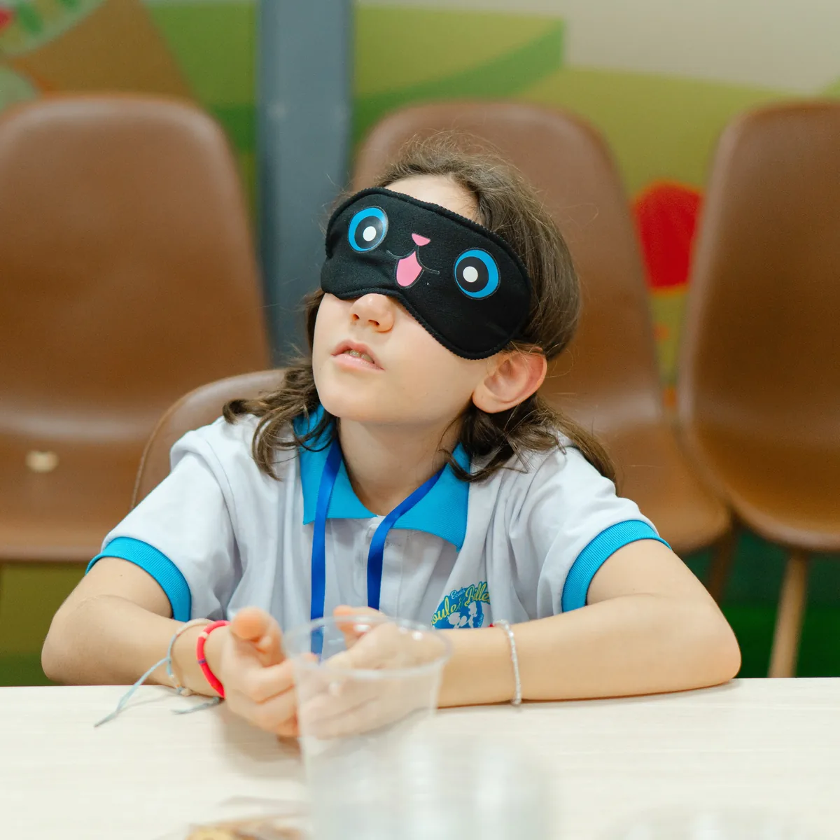 Une élève de CM1, les yeux masqués, goûte à l'aveugle pendant les Jeux francophones du Goût