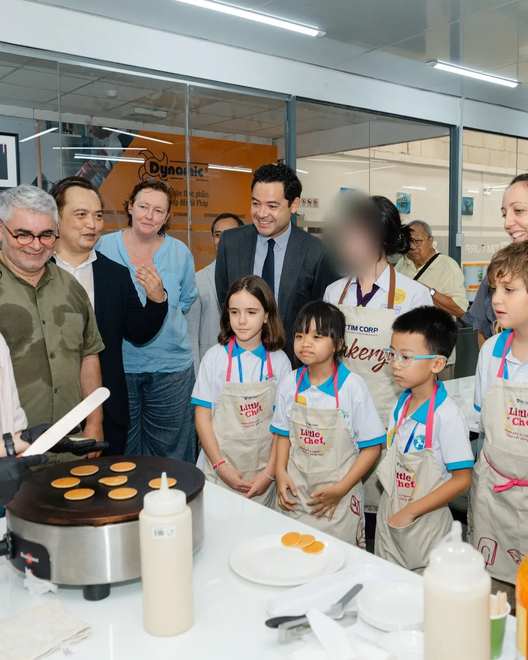 Le Consul général de France Etienne Ranaivoson et nos élèves de CM1 à l'atelier crêpes des Jeux francophones du Goût 2026