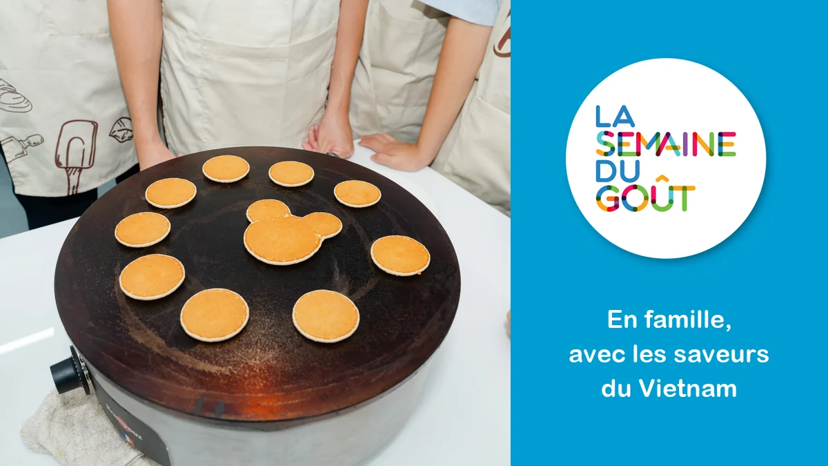 Des crêpes en forme de souris cuisent sur une crêpière pendant les Jeux francophones du Goût, à côté du logo de la Semaine du goût et de la mention « En famille, avec les saveurs du Vietnam »
