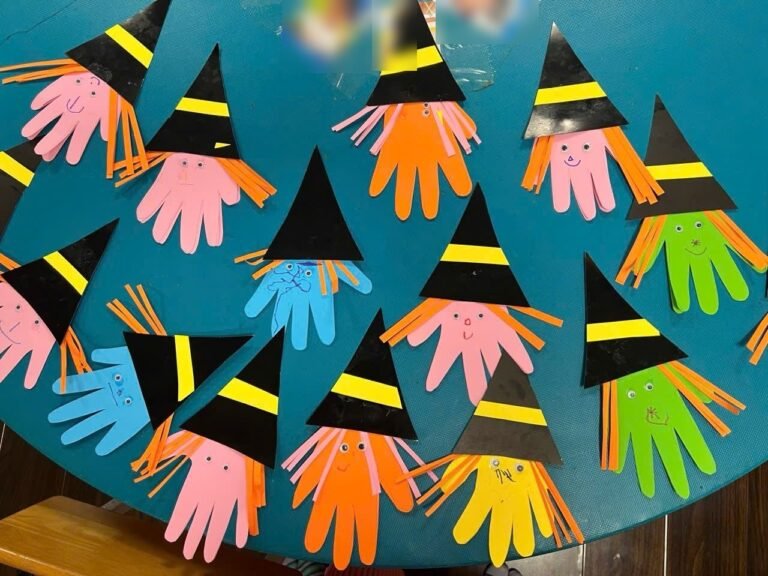 Paper witches made from cut-out hands in every color